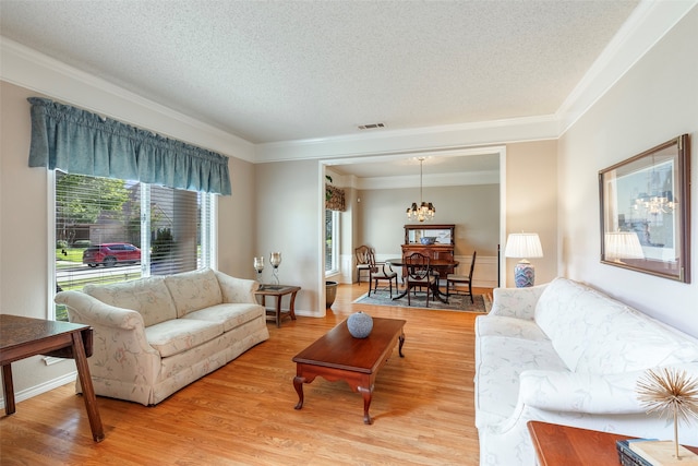 living room featuring crown molding, light wood-type flooring, and a wealth of natural light