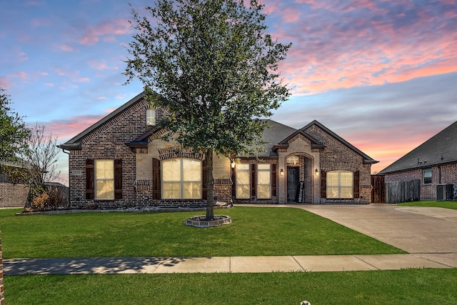 french country style house with a lawn and cooling unit