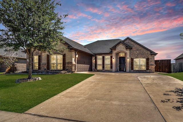 french country style house with a garage and a lawn