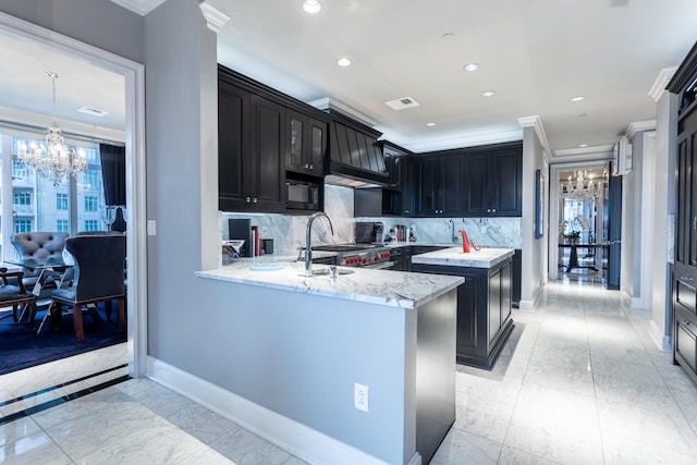 kitchen with backsplash, kitchen peninsula, decorative light fixtures, ornamental molding, and a notable chandelier