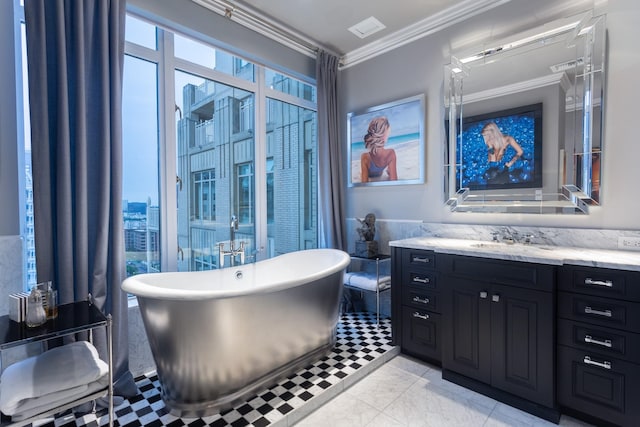 bathroom with ornamental molding, a tub to relax in, plenty of natural light, and vanity