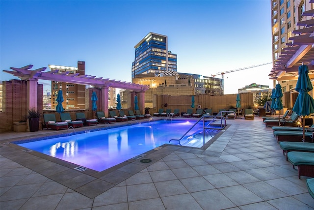 pool at dusk featuring a patio, a pergola, and a jacuzzi