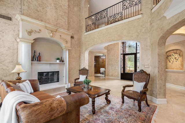 tiled living room with crown molding and a towering ceiling