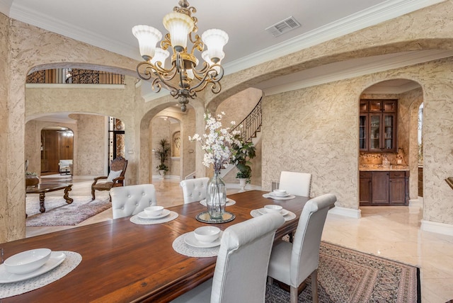 dining area with crown molding and a chandelier