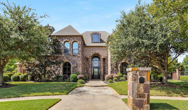 french provincial home with a front yard