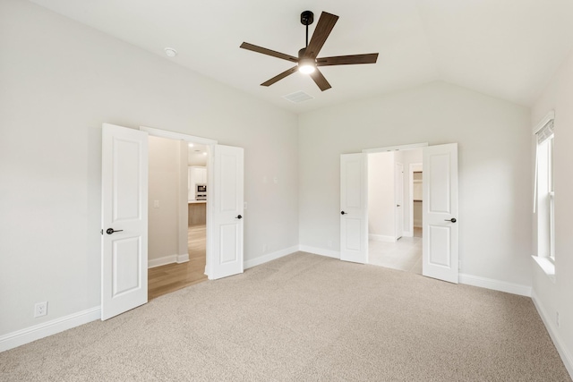 unfurnished bedroom with ceiling fan, light carpet, and vaulted ceiling