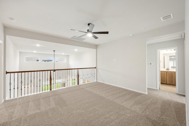 carpeted empty room featuring ceiling fan and sink