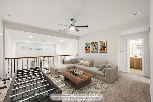 living room with ceiling fan, light colored carpet, and sink