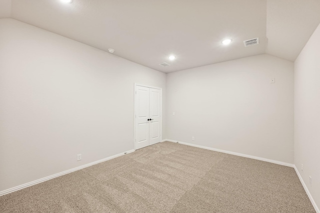 carpeted spare room with lofted ceiling