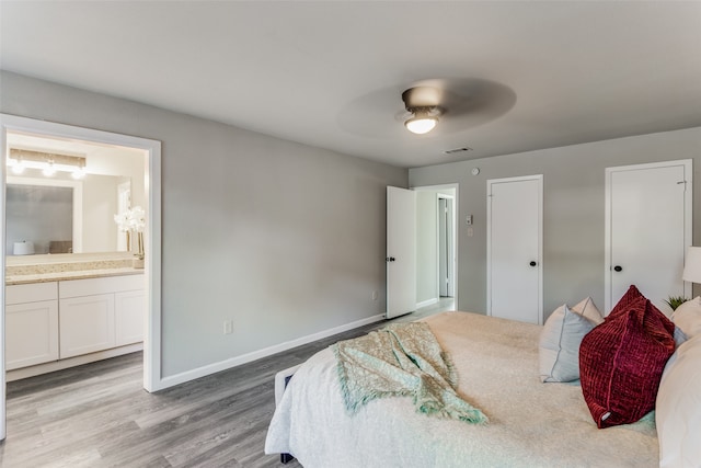 bedroom featuring ceiling fan, light wood-type flooring, and ensuite bathroom