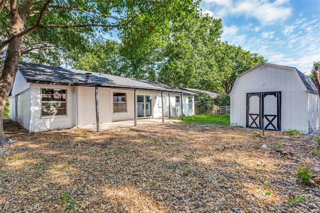 rear view of property featuring a storage shed, an outbuilding, and a patio area