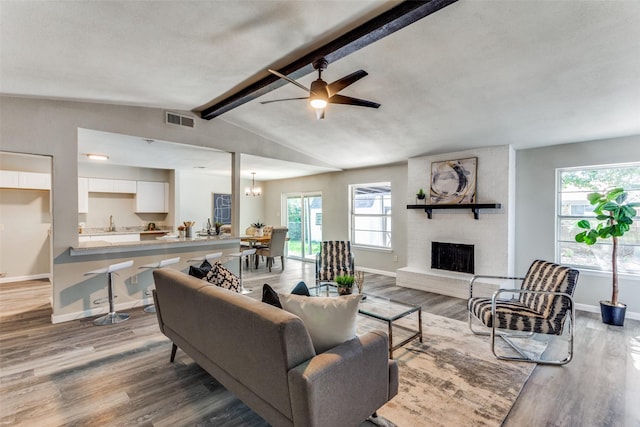 living area with visible vents, baseboards, a healthy amount of sunlight, and a fireplace
