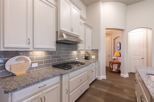 kitchen with stainless steel gas stovetop, light stone countertops, dark wood-type flooring, and white cabinets