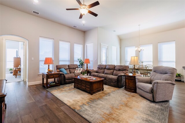 living room with ceiling fan with notable chandelier, plenty of natural light, and hardwood / wood-style floors