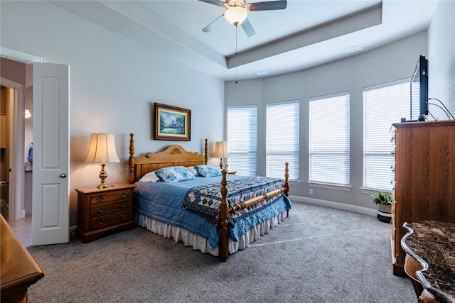 bedroom with ceiling fan, a raised ceiling, and carpet