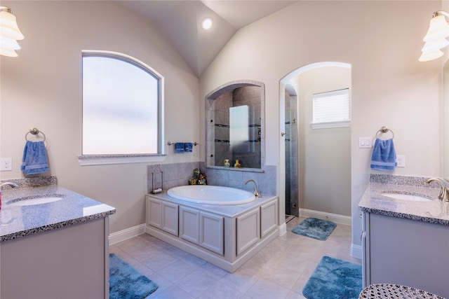 bathroom featuring shower with separate bathtub, lofted ceiling, tile patterned floors, and vanity