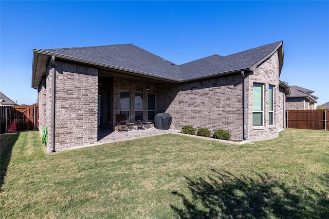 back of property featuring a lawn and a patio