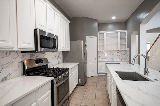 kitchen featuring stainless steel appliances, white cabinetry, tasteful backsplash, and sink