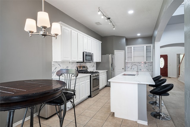 kitchen featuring pendant lighting, light tile patterned flooring, sink, white cabinetry, and appliances with stainless steel finishes