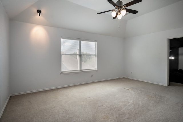 carpeted spare room featuring lofted ceiling and ceiling fan