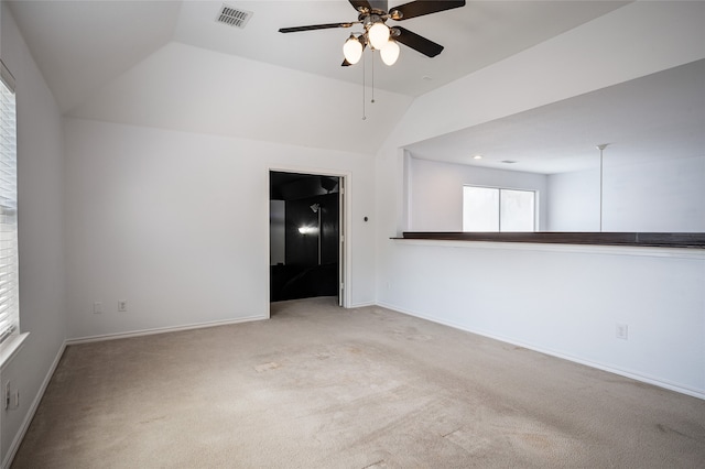 spare room with lofted ceiling, ceiling fan, and light colored carpet