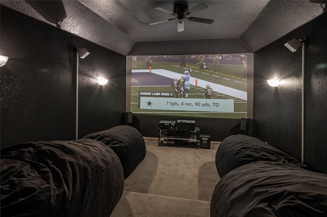 cinema room featuring ceiling fan, lofted ceiling, a textured ceiling, and carpet flooring