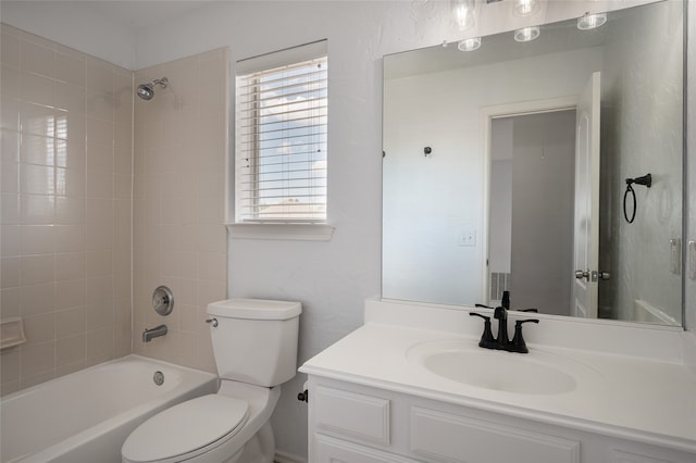 full bathroom with tiled shower / bath, vanity, and toilet