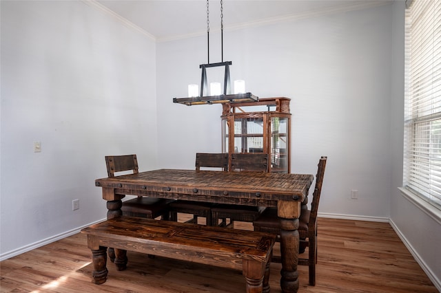 dining room featuring wood-type flooring and crown molding