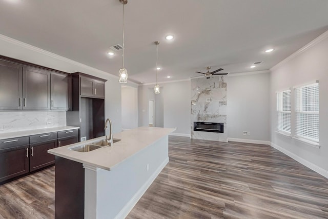 kitchen featuring ceiling fan, sink, decorative light fixtures, dark hardwood / wood-style floors, and a fireplace