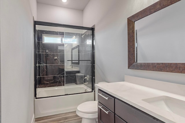 full bathroom featuring shower / bath combination with glass door, toilet, vanity, and hardwood / wood-style floors