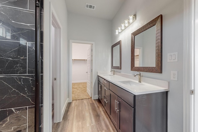 bathroom with lofted ceiling, hardwood / wood-style floors, and vanity