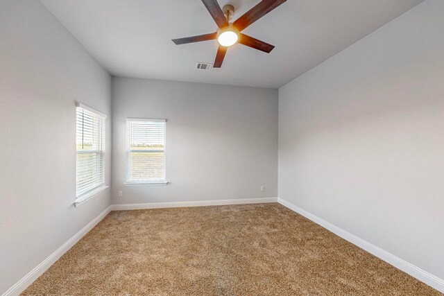 carpeted spare room featuring ceiling fan