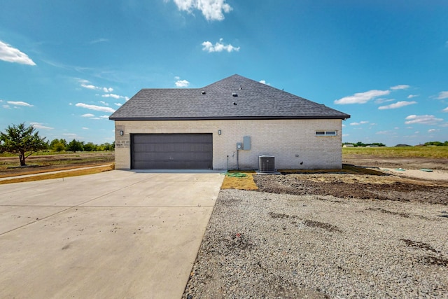 view of side of property featuring central AC and a garage