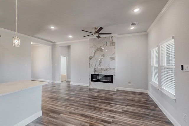 unfurnished living room with ornamental molding, a premium fireplace, ceiling fan, and dark hardwood / wood-style flooring