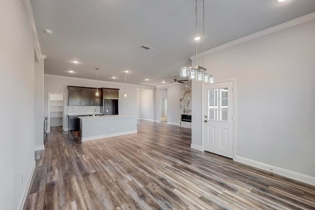 unfurnished living room with crown molding, dark wood-type flooring, ceiling fan, and sink