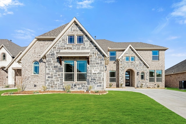 view of front of property with a front yard and central air condition unit