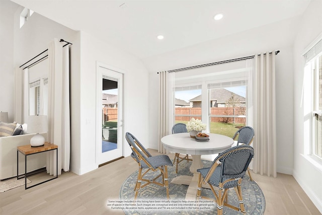 dining area featuring light hardwood / wood-style floors and lofted ceiling