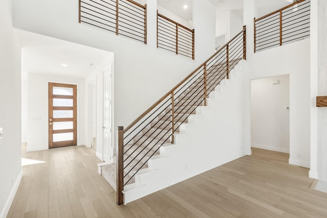 entrance foyer featuring light hardwood / wood-style flooring and a high ceiling