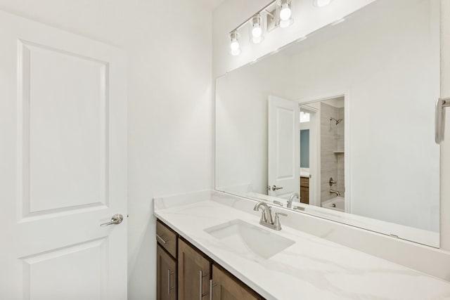 bathroom with tiled shower / bath combo and vanity