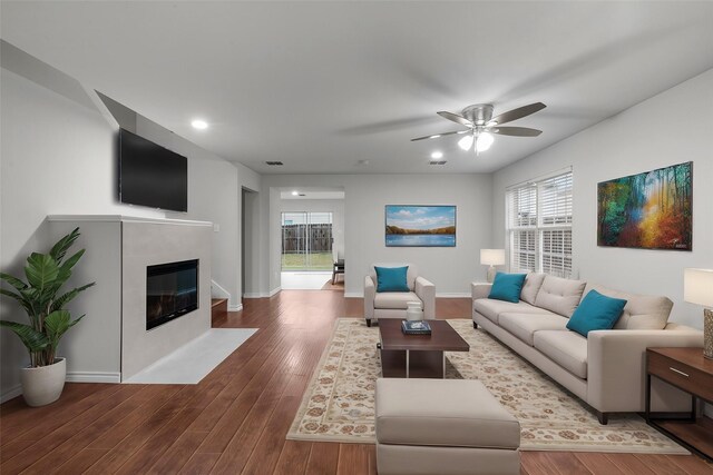 unfurnished living room with dark wood-type flooring, ceiling fan, and plenty of natural light