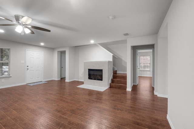 unfurnished living room featuring ceiling fan and dark wood-type flooring