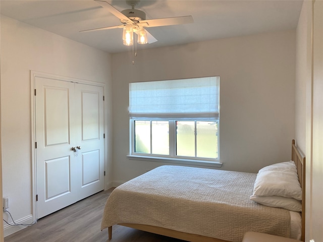 bedroom with ceiling fan, a closet, and light hardwood / wood-style floors