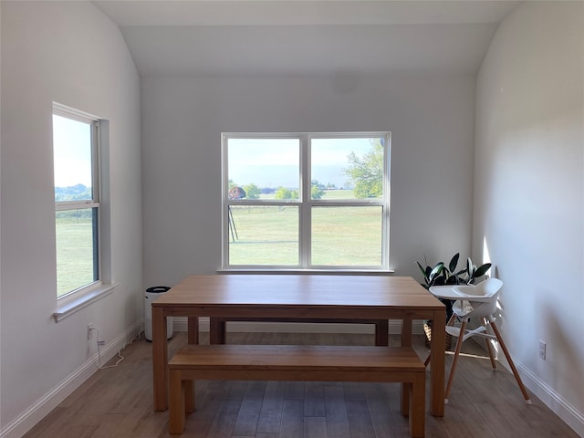 dining area featuring hardwood / wood-style flooring and lofted ceiling