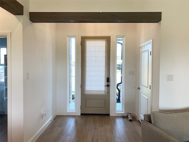 entryway with wood-type flooring and beamed ceiling