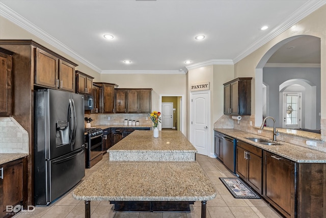 kitchen featuring a breakfast bar, a center island, sink, appliances with stainless steel finishes, and crown molding