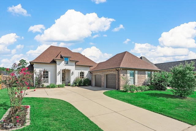 french provincial home featuring a front yard and a garage