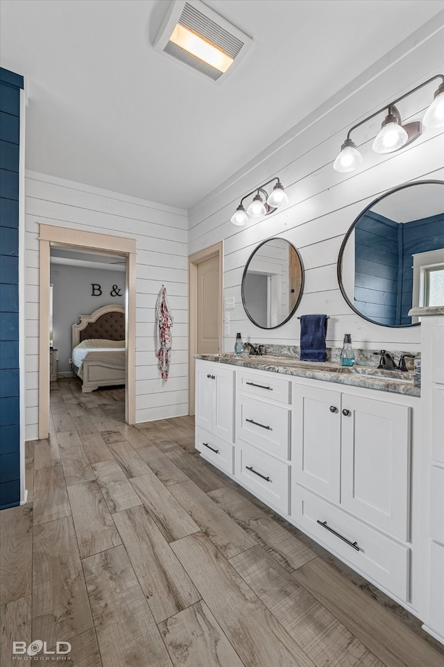 bathroom featuring vanity, wood walls, and hardwood / wood-style flooring