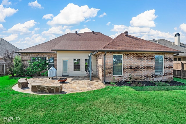 back of house with a lawn, a patio area, and an outdoor fire pit