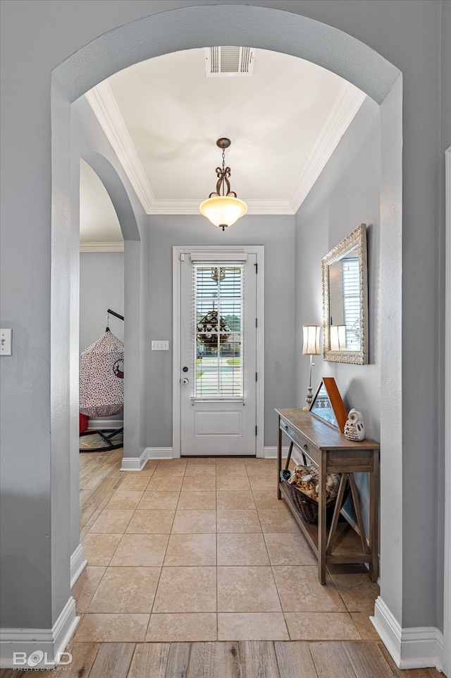 entrance foyer featuring crown molding, light hardwood / wood-style floors, and a raised ceiling