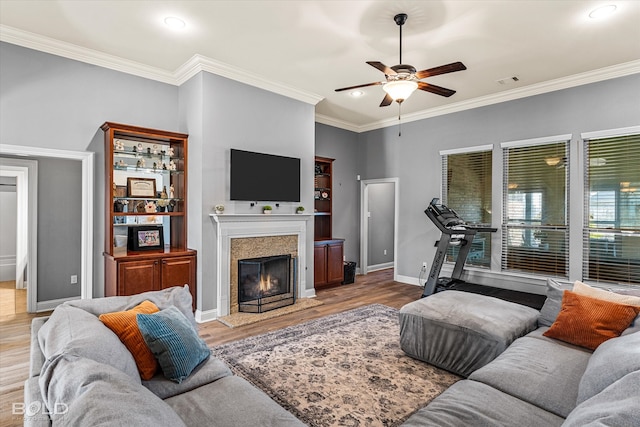 living room featuring crown molding, ceiling fan, and light hardwood / wood-style flooring